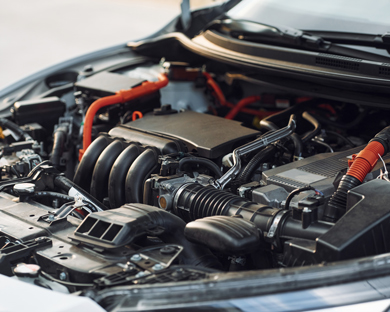 car engine compartment with visible components and wiring featuring six cylinders and multiple hoses