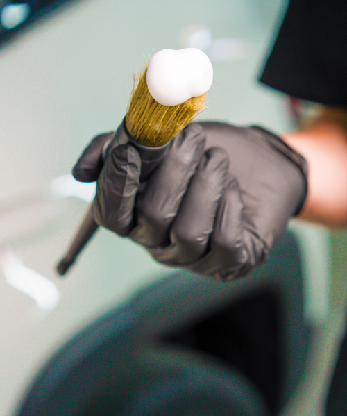 person holding brush with foam shaving cream in hand for grooming 2 styles 2 shaving methods