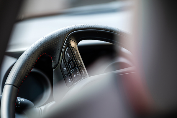 close up of a modern car steering wheel with controls and a sleek design symbolizing vehicle performance and driving experience