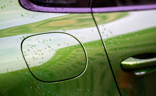 green car close-up with water droplets showing reflection and fuel cap detail 1 automotive design features