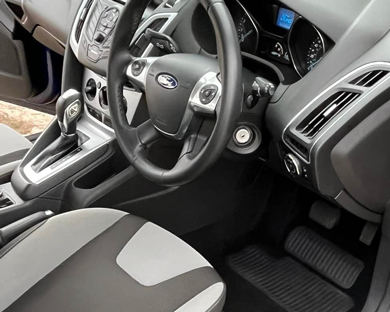 Ford car interior with modern design features and controls displaying advanced technology for drivers. Comfortable seating and ergonomic layout enhance driving experience.