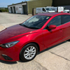 red car parked on asphalt surrounded by buildings compact model with shiny exterior and sleek design ideal for city driving